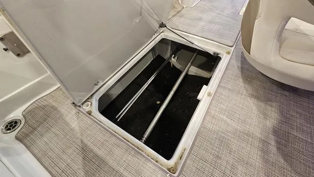 Slide: The Image of 2020 Crownline E 215 XS boat storage compartment with open hatch, revealing interior space. - 28