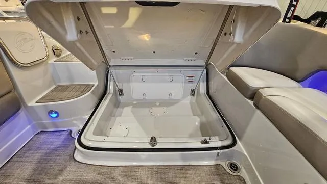 Slide: The Image of 2020 Crownline E 215 XS boat storage compartment, open with seating and blue lighting. - 30