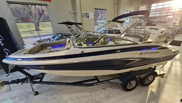 Slide: The Image of 2020 Crownline E 215 XS boat on trailer in showroom setting. - 4