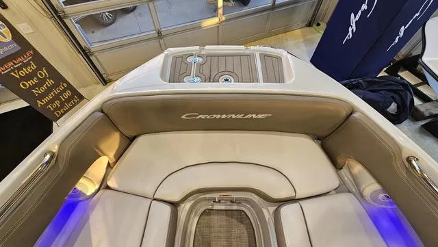 Slide: The Image of 2020 Crownline E 215 XS boat interior with cushioned seating and ambient lighting. - 22