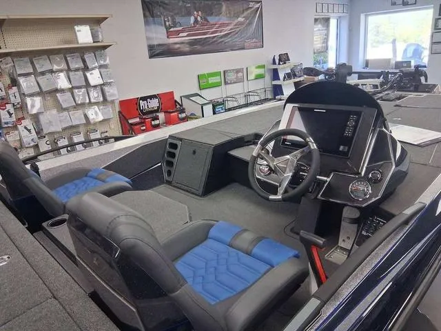 Slide: The Image of 2025 Vexus VX S20 boat interior with blue seats and modern dashboard in showroom. - 12