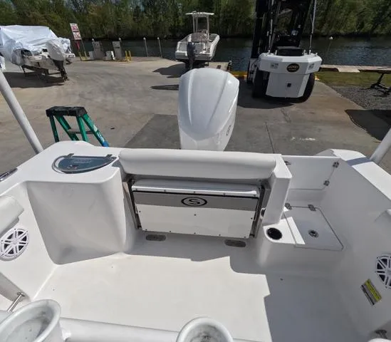 Slide: The Image of 2021 Sportsman Open 232 boat interior with seating and storage, docked near water. - 11