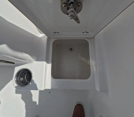 Slide: The Image of 2021 Sportsman Open 232 boat interior, featuring a storage compartment and cup holder. - 13