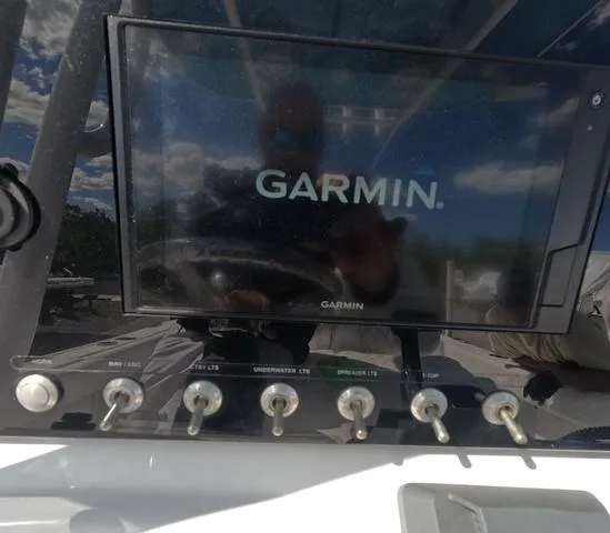 Slide: The Image of Garmin display on 2021 Sportsman Open 232 boat dashboard with control switches. - 21