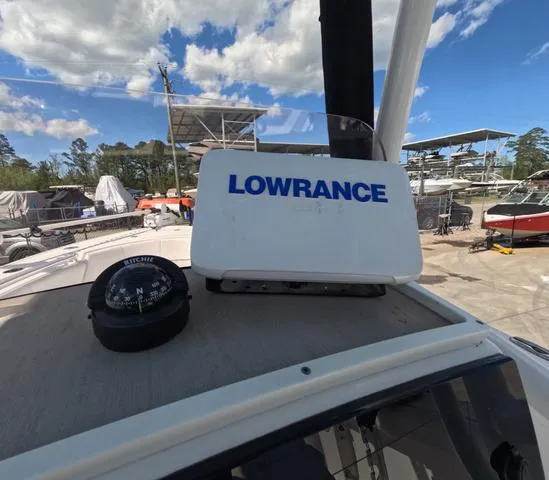 Slide: The Image of 2021 Sportsman Open 232 boat with Lowrance navigation system and compass, docked under blue sky. - 22