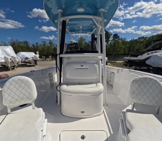 Slide: The Image of 2021 Sportsman Open 232 boat interior with white seating, blue canopy, and clear sky background. - 30