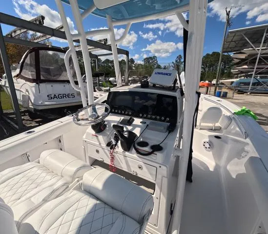 Slide: The Image of 2021 Sportsman Open 232 boat interior with steering console and seating, parked outdoors. - 42