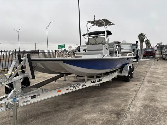 Slide: The Image of 2024 Majek M2 ILLUSION boat on trailer, blue and white, parked outdoors. - 3
