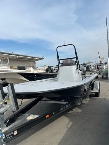 Slide: The Image of 2025 Majek 24 Reaper boat on trailer, parked outdoors under a clear sky. - 2