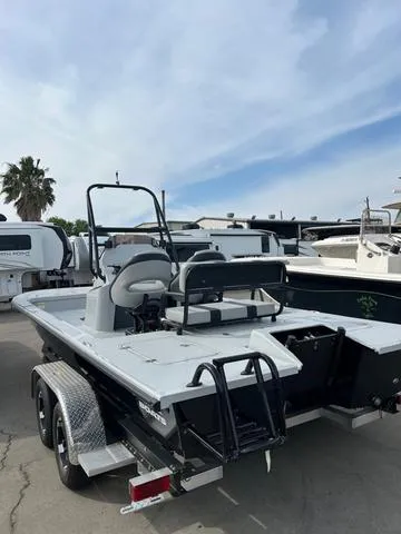 Slide: The Image of 2025 Majek 24 Reaper boat on trailer, parked outdoors, showcasing sleek design and spacious deck. - 4