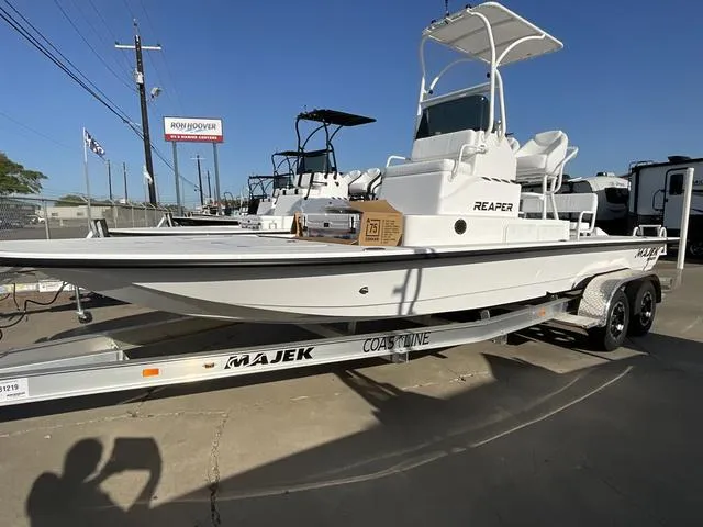 Slide: The Image of 2025 Majek 24 Reaper boat on trailer, displayed outdoors under clear blue sky. - 1