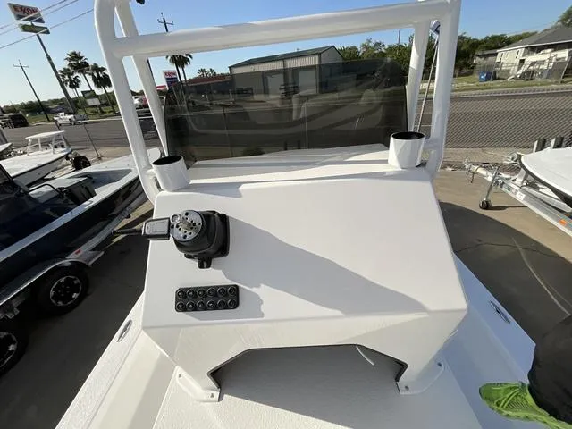 Slide: The Image of 2025 Majek 24 Reaper boat console with steering and controls, docked outdoors. - 11