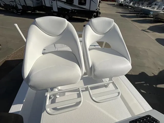 Slide: The Image of Two white seats on a 2025 Majek 24 Reaper boat, parked in a marina. - 12