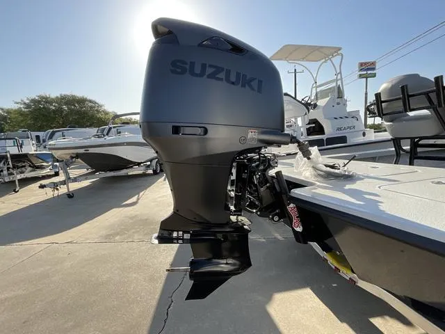 Slide: The Image of 2025 Majek 22 XTREME boat with Suzuki outboard motor in a sunny marina. - 6