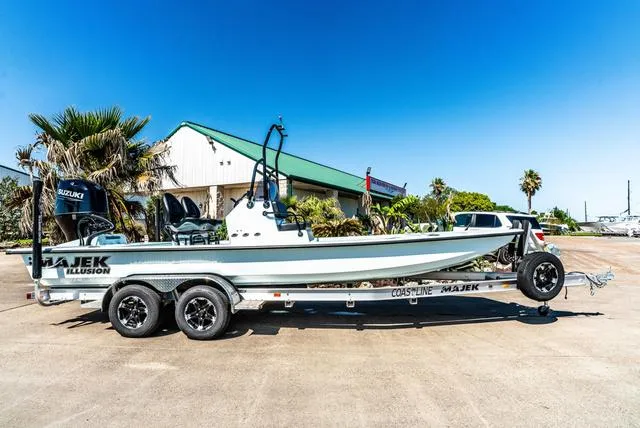 Slide: The Image of 2025 Majek 2206 Illusion boat on trailer, parked outdoors under clear blue sky. - 1