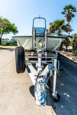 Slide: The Image of 2025 Majek 2206 Illusion boat on trailer, parked outdoors with palm trees in background. - 3