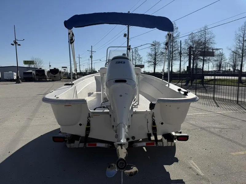 Slide: The Image of 2011 NauticStar 190R RG boat with blue canopy, parked on a trailer in a lot. - 4