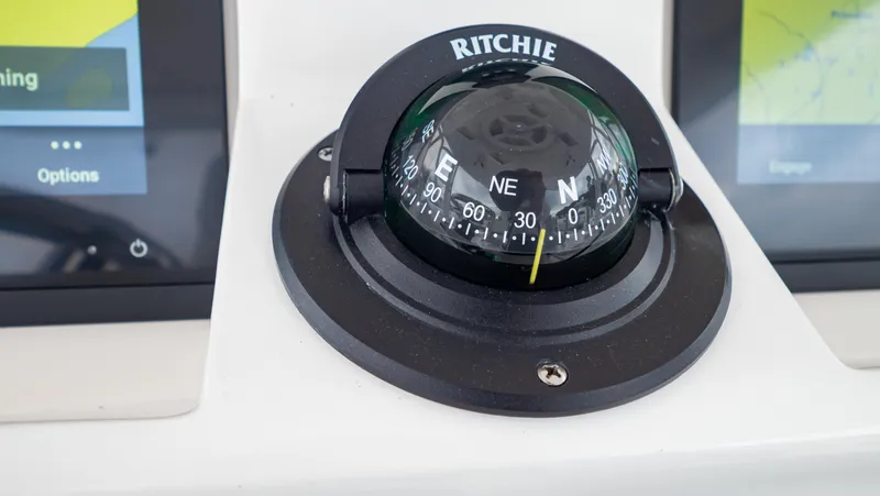 Slide: The Image of Compass on 2022 Intrepid 409 Valor boat dashboard, flanked by digital screens. - 13