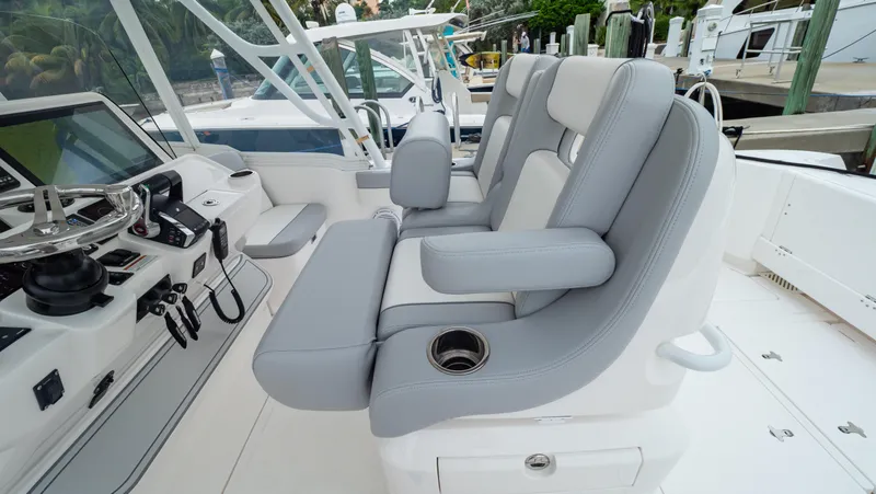 Slide: The Image of 2022 Intrepid 409 Valor boat interior with gray seating and modern helm controls. - 2