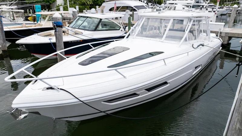 Slide: The Image of 2022 Intrepid 409 Valor boat docked in marina, sleek white design. - 27