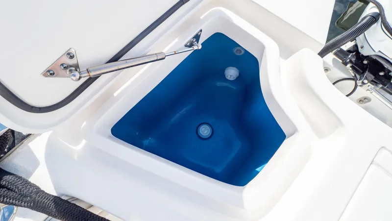 Slide: The Image of Open storage compartment on 2022 Intrepid 409 Valor boat, featuring a blue interior. - 38