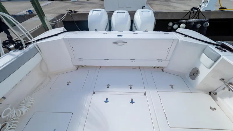 Slide: The Image of 2022 Intrepid 409 Valor boat deck with triple outboard engines, spacious storage compartments. - 43
