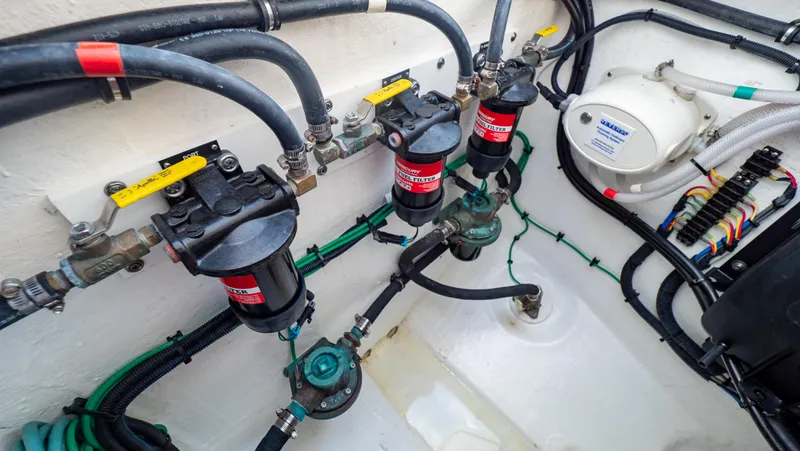 Slide: The Image of Engine compartment of 2022 Intrepid 409 Valor boat, showcasing fuel filters and hoses. - 49