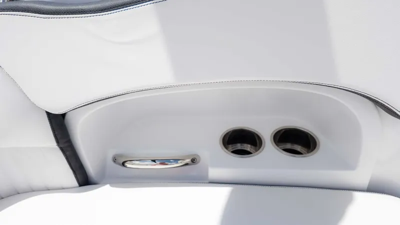 Slide: The Image of 2025 Stingray 211DC boat interior with cup holders and sleek white upholstery. - 11