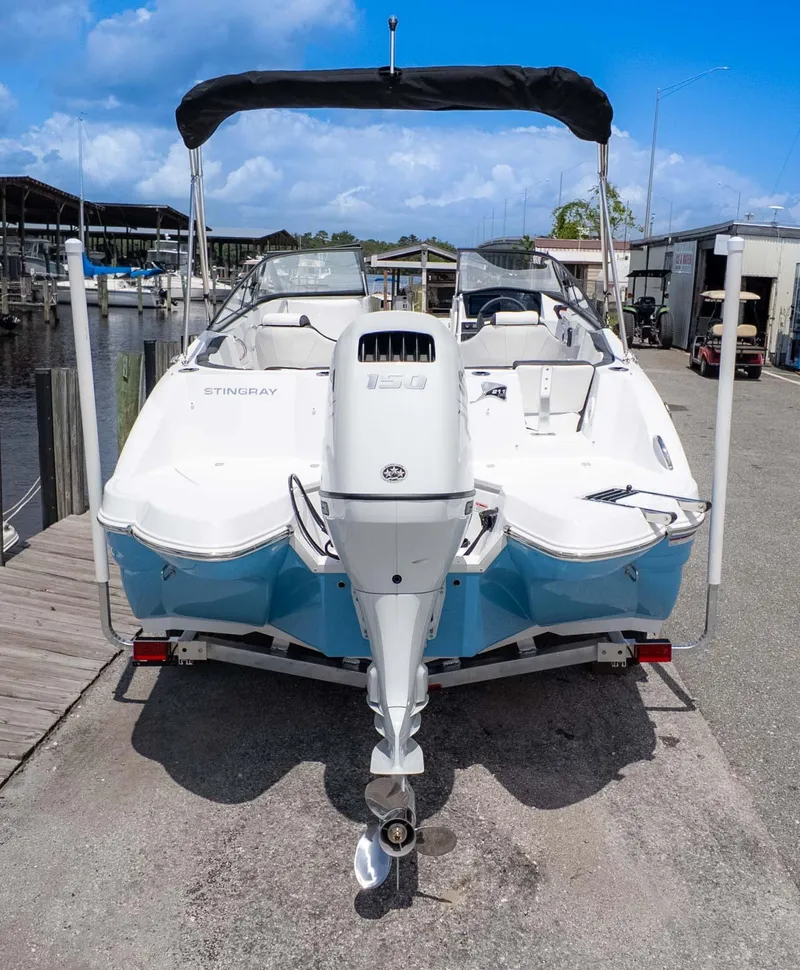 Slide: The Image of 2025 Stingray 211DC boat with outboard motor, docked under a clear blue sky. - 4