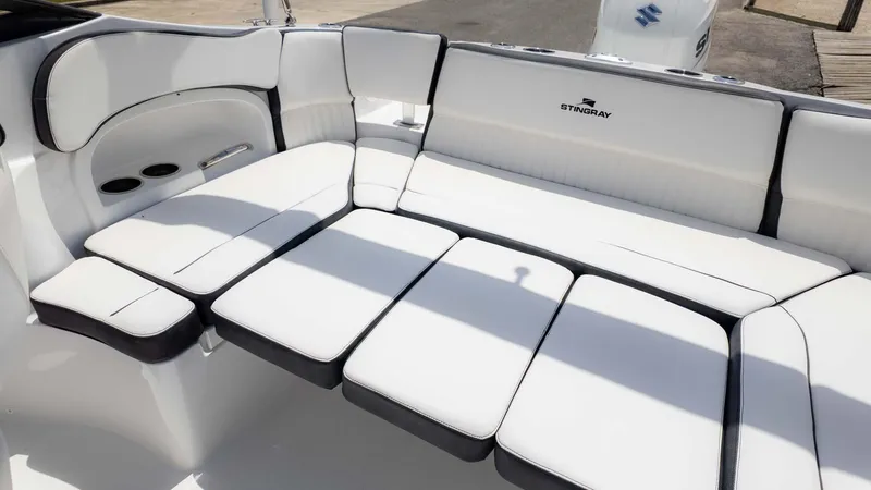 Slide: The Image of 2025 Stingray 211DC boat interior with white cushioned seating and sleek design. - 8