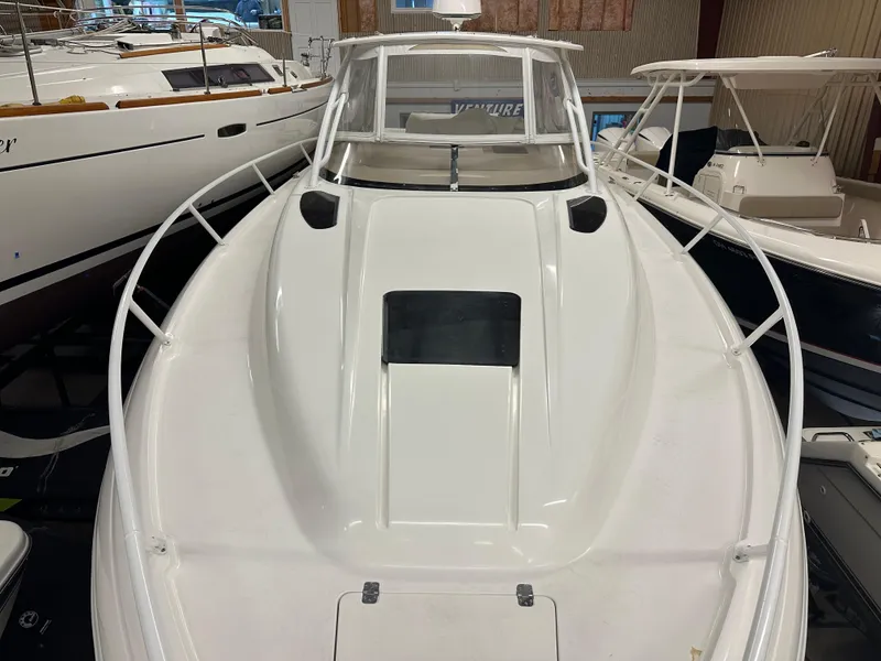 Slide: The Image of 2005 Intrepid 377 Walkaround boat, white exterior, docked indoors, showcasing sleek design and spacious deck. - 2