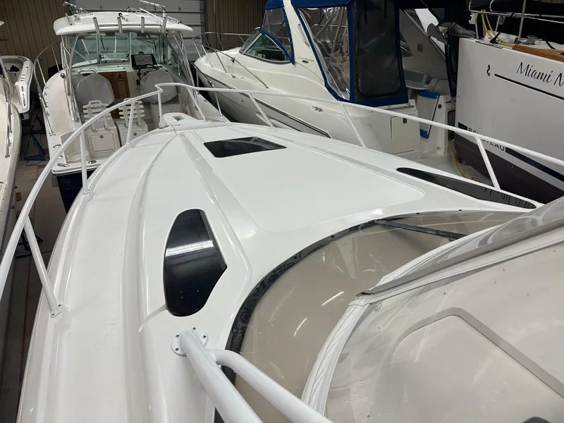 Slide: The Image of 2005 Intrepid 377 Walkaround boat in a marina, surrounded by other vessels. - 3