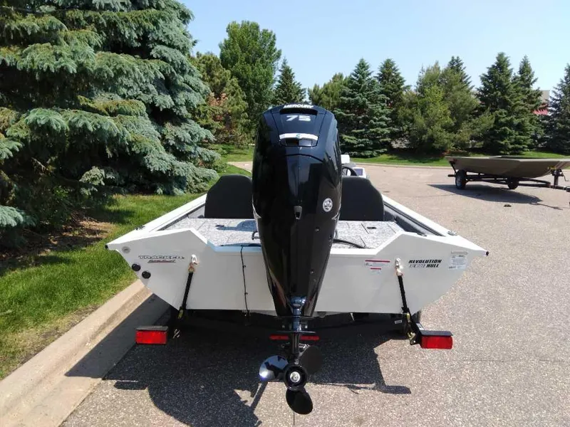 Slide: The Image of 2025 Tracker Pro Team 175 boat with 75 HP engine, parked on a sunny day. - 2