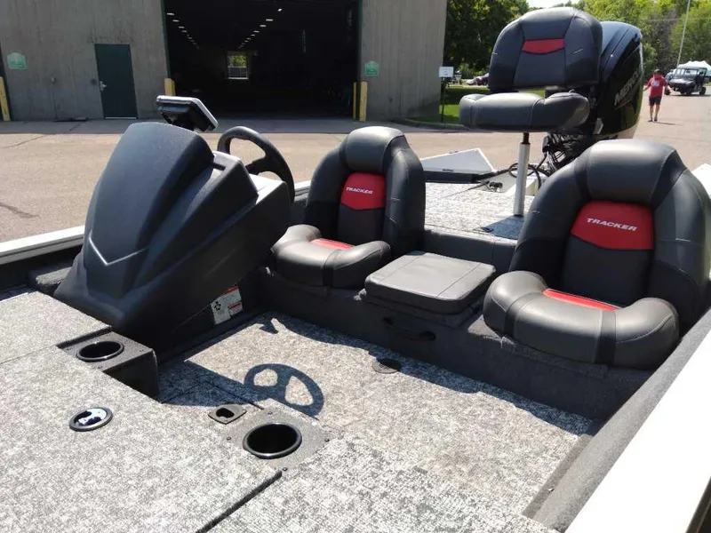 Slide: The Image of 2025 Tracker Pro Team 175 boat interior with black and red seating, steering console, and carpeted deck. - 4