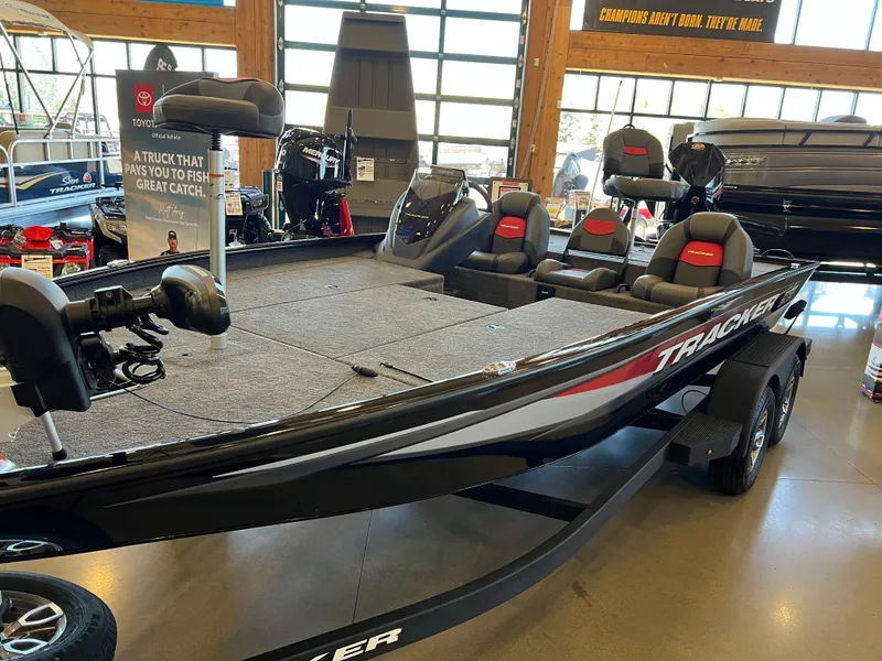 Slide: The Image of 2025 Tracker Savage 215 boat on display in showroom, featuring sleek design and comfortable seating. - 2