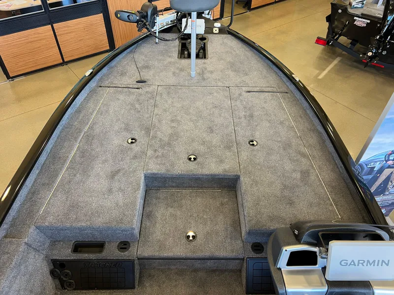 Slide: The Image of 2025 Tracker Savage 215 boat interior with Garmin equipment, featuring spacious carpeted deck. - 3