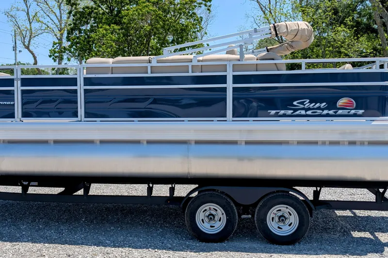 The Image of 2025 Sun Tracker Fishin' Barge 20 DLX pontoon boat on trailer, side view. - 0