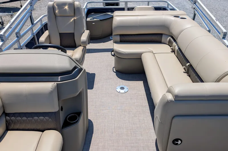 Slide: The Image of 2025 Sun Tracker Fishin' Barge 20 DLX interior with beige seating and steering console. - 8