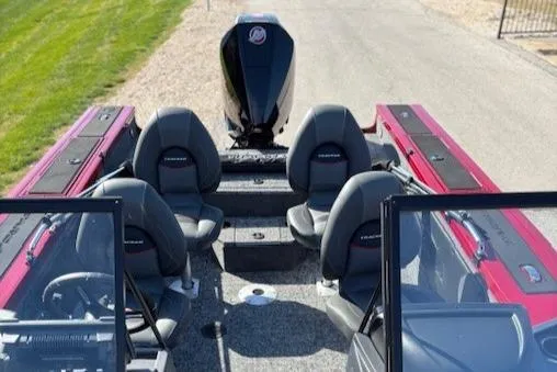 Slide: The Image of 2025 Tracker Targa V-19 Combo boat interior with seating and motor, parked on a paved path. - 3