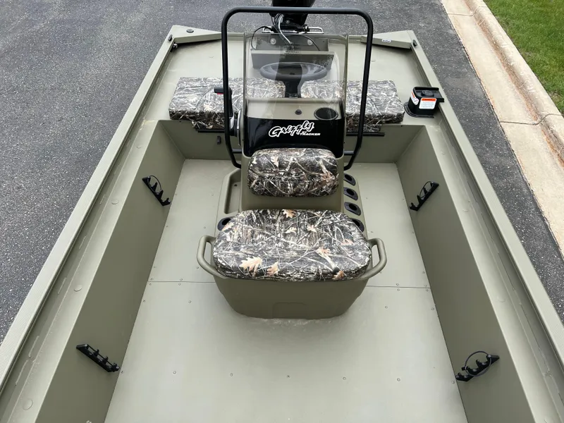Slide: The Image of 2025 Tracker Grizzly 1860 CC boat interior with camo seats and steering console. - 4