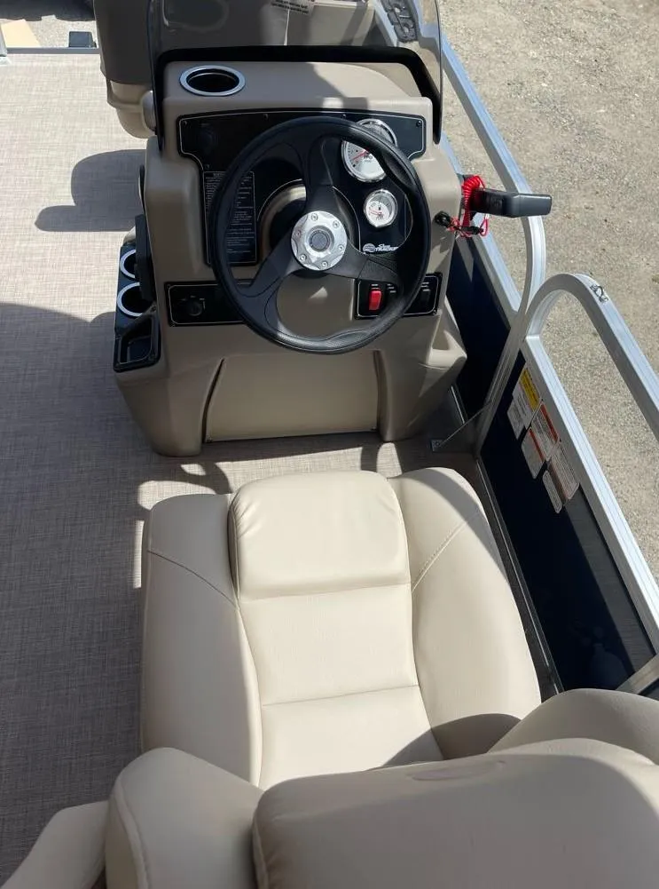 Slide: The Image of 2025 Sun Tracker Bass Buggy 18 DLX boat interior with steering wheel and beige seating. - 3