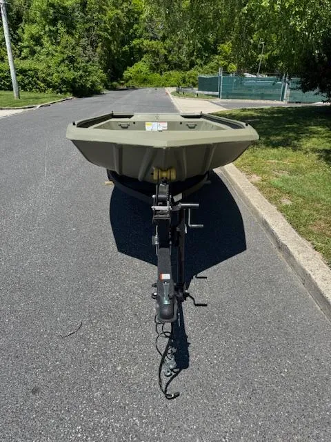 Slide: The Image of 2025 Tracker Grizzly 1648 Jon boat on a trailer, parked on a sunny street. - 3