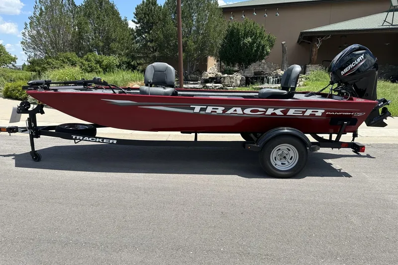 The Image of 2025 Tracker Panfish 17 boat on trailer, red exterior, parked outdoors. - 0