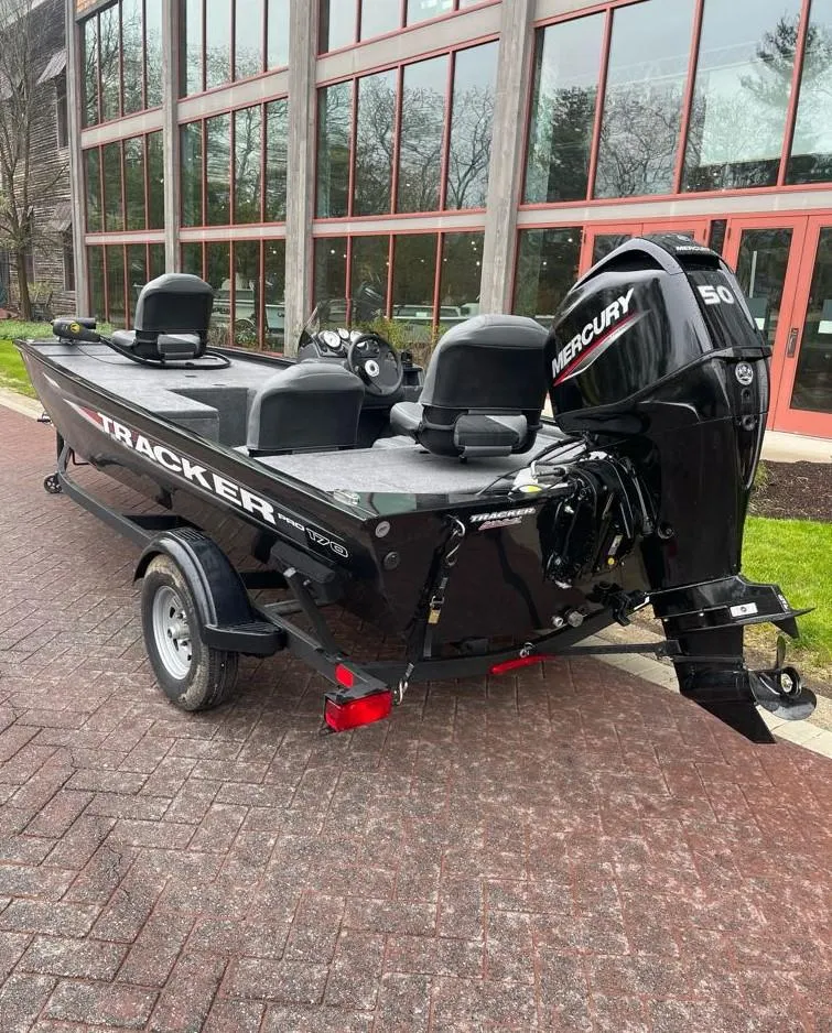 Slide: The Image of 2025 Tracker Pro 170 boat with Mercury engine, parked on brick pavement. - 3