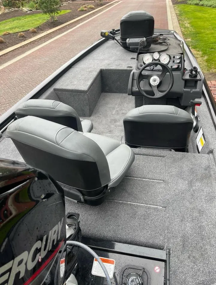 Slide: The Image of 2025 Tracker Pro 170 boat interior with steering wheel, seats, and Mercury engine. - 5