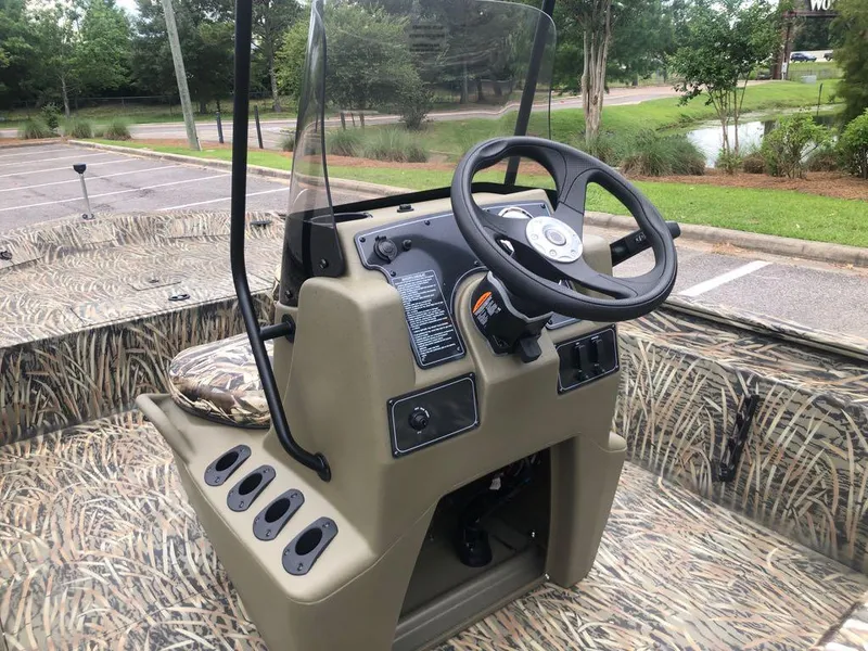 Slide: The Image of 2025 Tracker Grizzly 1860 CC boat console with steering wheel and camouflage design. - 11
