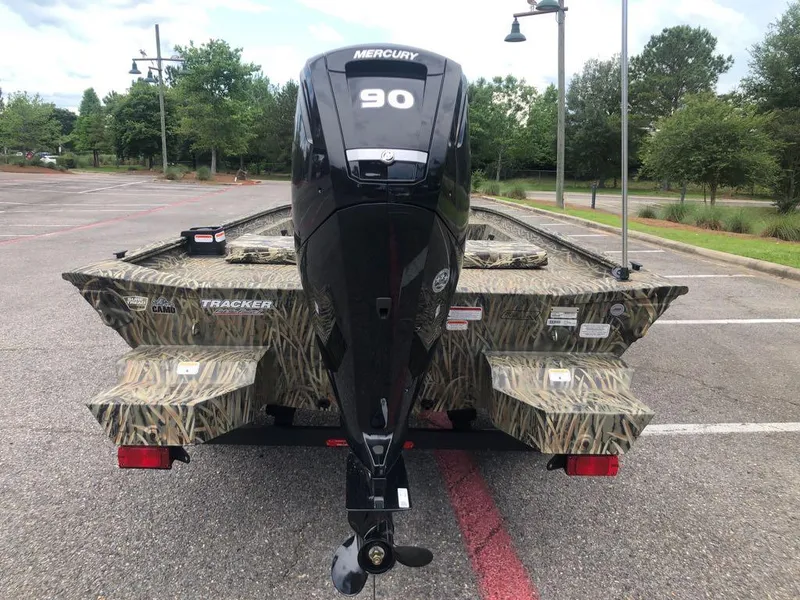 Slide: The Image of 2025 Tracker Grizzly 1860 CC boat with Mercury 90 engine in a parking lot. - 2