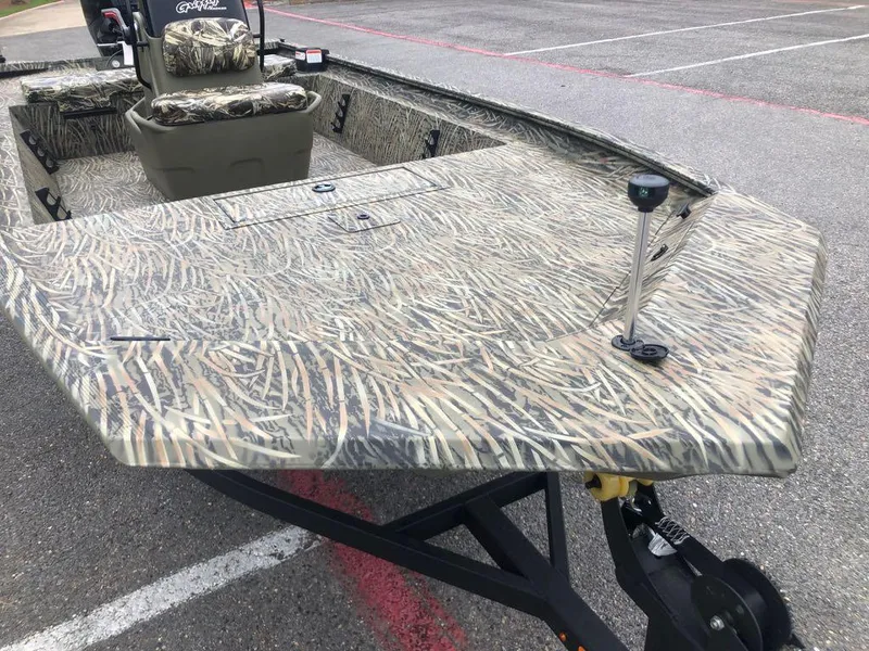 Slide: The Image of 2025 Tracker Grizzly 1860 CC boat with camouflage design in a parking lot. - 8