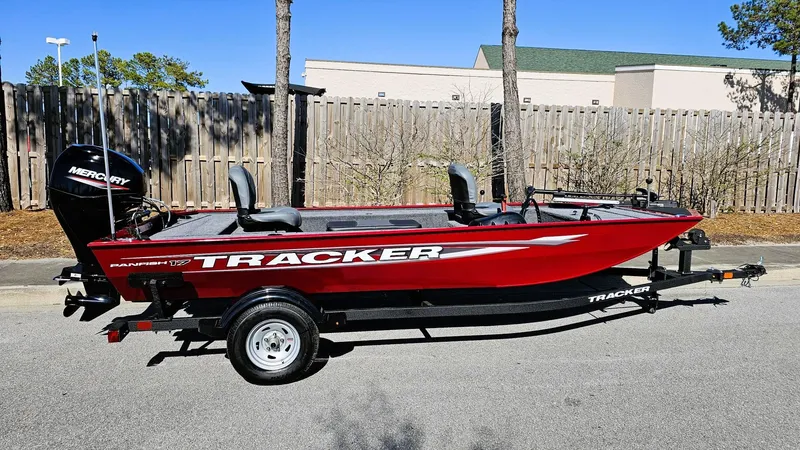 Slide: The Image of 2025 Tracker Panfish 17 boat, red, on trailer, parked outdoors, side view. - 3