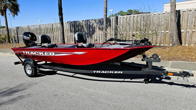 Slide: The Image of 2025 Tracker Panfish 17 boat in vibrant red on a trailer, parked outdoors. - 4